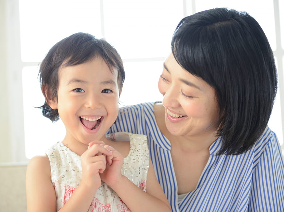 よろこぶ幼児とそれを見つめる母親